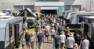 Attendees browse new caravans and RVs at a 2026 caravan show, exploring finance options.